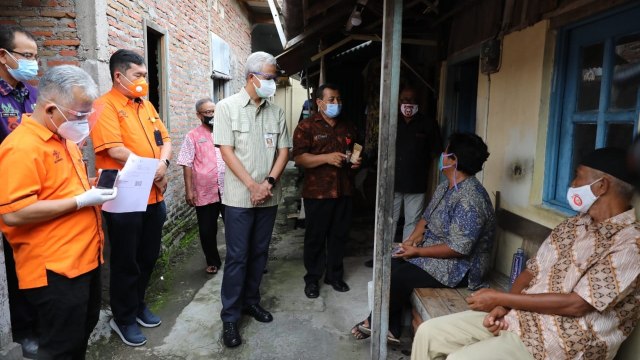 Gubernur Jawa Tengah Ganjar Pranowo saat mendampingi PT POS menyerahkan BST kepada dua lansia di Kelurahan Sangkrah Kecamatan Pasar Kliwon Solo. Foto: Pemprov Jateng