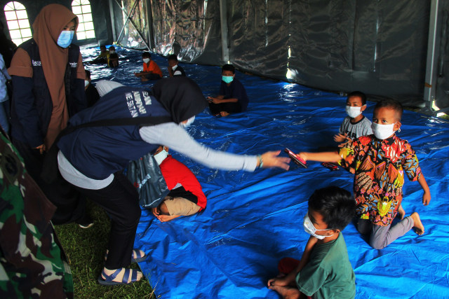 Sejumlah anak pengungsi korban gempa bumi mengikuti kegiatan trauma healing di lokasi pengungsian Stadion Manakarra Mamuju, Sulawesi Barat, Selasa (19/1).  Foto: Akbar Tado/ANTARA FOTO