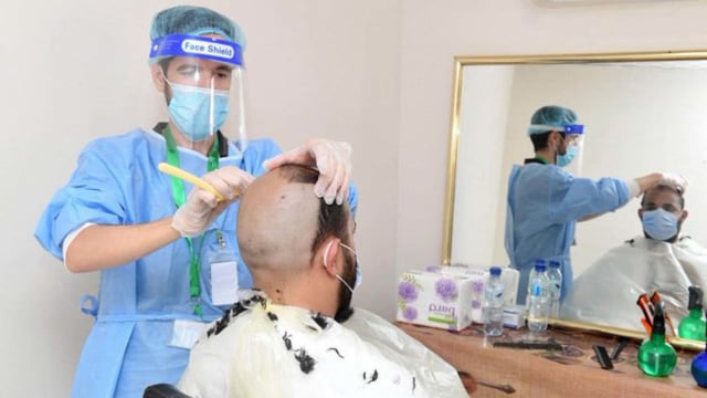 Jemaah haji 2020 setelah tawaf ifadah mencukur rambut (tahallul), Jumat (31/6). Petugas cukur  memakai APD sebagai protokol kesehatan. Foto: Twitter/@hsharifain