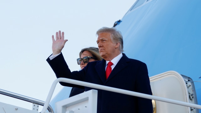 Presiden AS Donald Trump bersama ibu negara Melania Trump saat melambaikan tangan sebelum berangkat dari Joint Base Andrews, Maryland, AS, Rabu (20/1). Foto: Carlos Barria/REUTERS