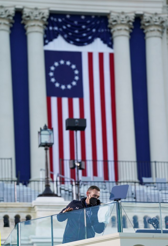 Kaca anti peluru dibersihkan sebelum pelantikan Joe Biden sebagai Presiden ke-46 Amerika Serikat di Front Barat Capitol AS di Washington, AS, Rabu (20/1). Foto: Kevin Lamarque/REUTERS