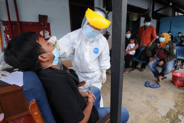 Petugas kesehatan melakukan tes cepat antigen kepada pengungsi gempa Sulawesi Barat saat tiba di Landasan Udara Adi Soemarmo, Boyolali, Jawa Tengah, Kamis (21/1).  Foto: Aloysius Jarot Nugroho/ANTARA FOTO