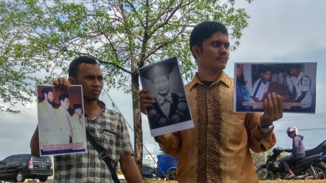 Aktivis Aceh memegang foto para tokoh Aceh yang ditembak semasa konflik saat napak tilas sejumlah titik konflik Aceh. Foto: Fuadi/KontraS Aceh