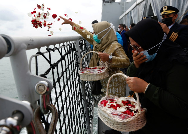 Anggota keluarga korban kecelakaan Sriwijaya Air  SJ 182 menaburkan bunga dari geladak kapal TNI AL KRI Semarang, di laut lepas, Kepulauan Seribu, Jakarta, Jumat (22/1). Foto: Ajeng Dinar Ulfiana/REUTERS
