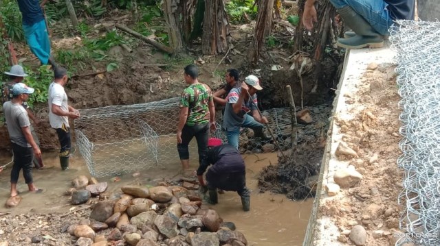 TNI bersama waga memperbaiki tanggul sungai di Aceh Utara. Foto: Dok. Laung/TNI