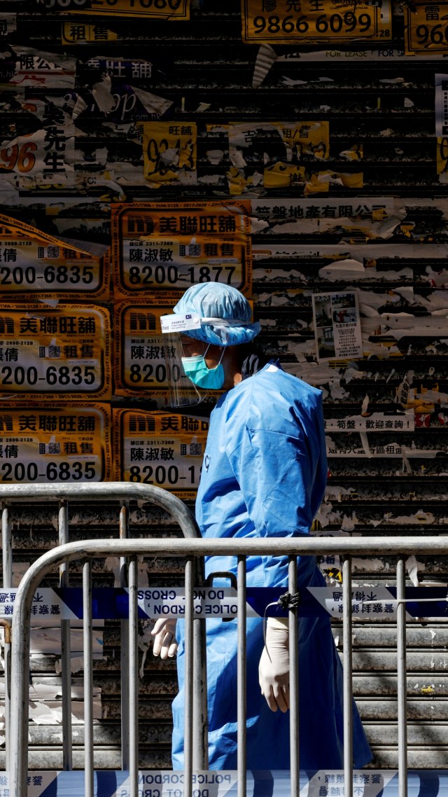Petugas kesehatan terlihat mengenakan APD saat penguncian sebagian wilayah di permukiman Yordania, di Hong Kong, China, Sabtu (23/1). Foto: Tyrone Siu/REUTERS