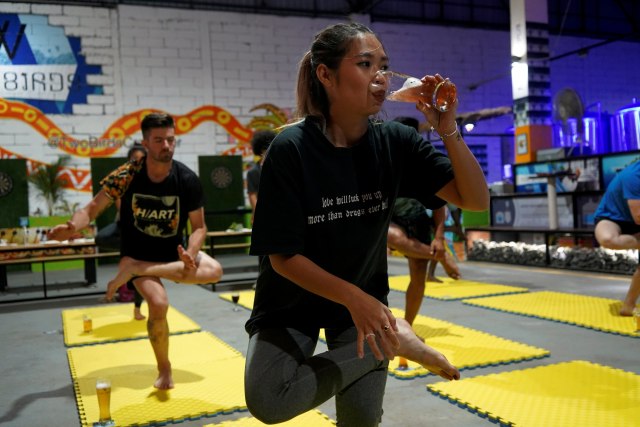 Orang-orang mengikuti sesi yoga bir di tempat pembuatan bir, Phnom Penh, Kamboja. Foto: Cindy Liu/REUTERS