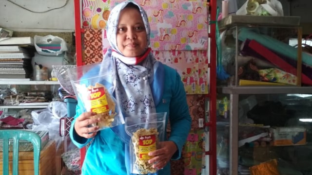 Siti Mutmainah (38), guru madarasah asal Desa Talok Kecamatan Kalitidu Kabupaten Bojonegoro, dengan rempeyek produksinya. (foto: vera/beritabojonegoro)