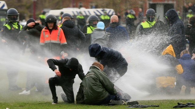 Polisi menggunakan water canon membubarkan demonstrasi selama protes terhadap pembatasan yang diberlakukan di Amsterdam, Belanda. Foto: Eva Plevier/REUTERS