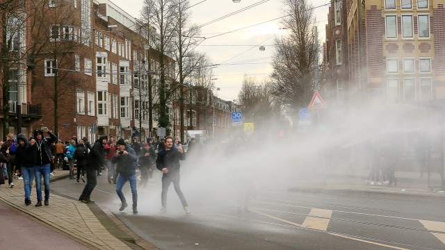 Polisi menggunakan water canon membubarkan demonstrasi selama protes terhadap pembatasan yang diberlakukan di Amsterdam, Belanda. Foto: Eva Plevier/REUTERS