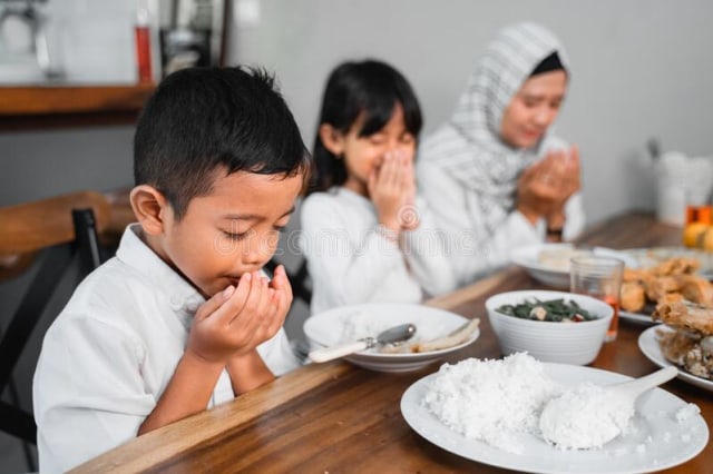 Ilustrasi keluarga yang membaca doa sebelum menyantap makanan. Sumber: dreamstime