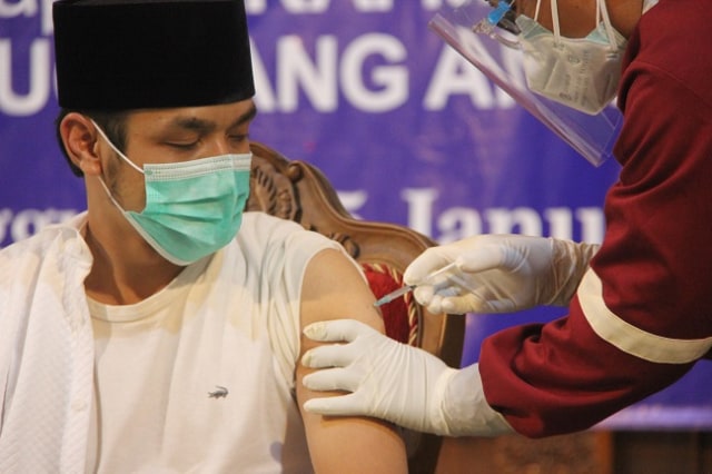 Salah satu tokoh masyarakat Gus Lamik, diusntik vaksin COVID-19 di Pendapa Pengayoman Temanggung, Jawa Tengah, Senin (25/1/2021). Foto: ari/Tugu Jogja