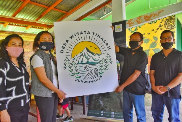 Tim Abdimas UAJY bersama dengan pengelola Desa Wisata Tinalah saat menunjukkan logo Desa Wisata Tinalah. Foto: dok. UAJY.
