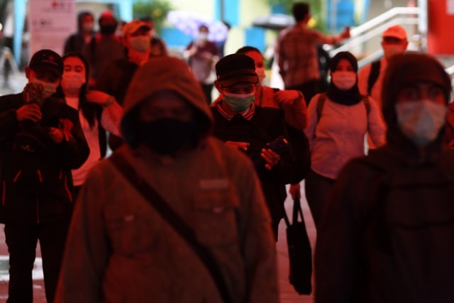 Masyarakat menggunakan masker saat berjalan melintasi terowongan Kendal, Jakarta, Selasa (26/1). Foto: Wahyu Putro A/Antara Foto