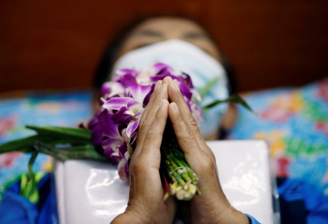 Seorang pemuja berbaring dan berdoa di dalam peti mati sebuah kuil di Bangkok, Thailand. Foto: Soe Zeya Tun/REUTERS