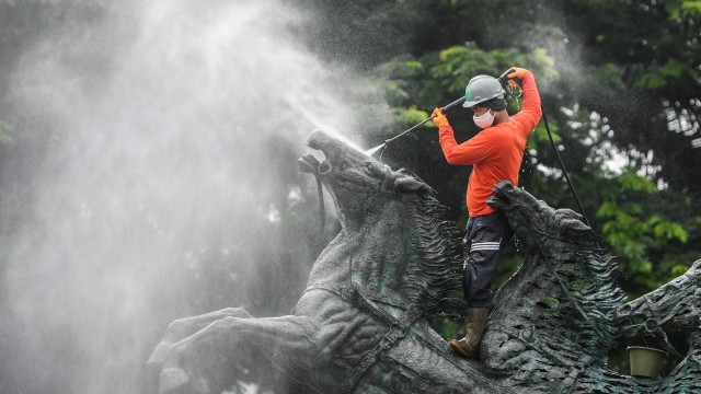 Pekerja membersihkan patung Asta Brata (Arjuna Wijaya) di jalan Medan Merdeka Barat, Jakarta, Rabu (27/1). Foto: Galih Pradipta/ANTARA FOTO