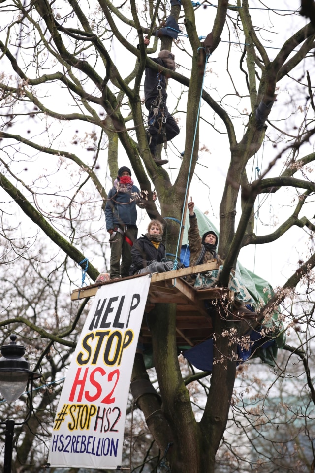 Para pengunjuk rasa duduk di atas pepohonan di perkemahan di Euston Square Gardens di pusat kota London, Inggris, Rabu (27/1). Foto: Aaron Chown/PA via AP