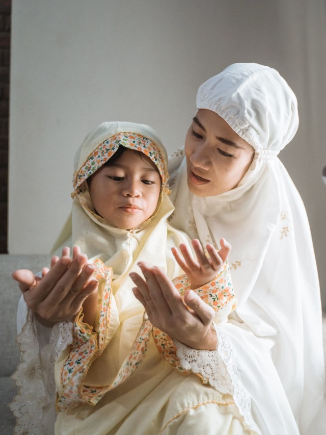 Ilustrasi ibu berhijab ajarkan anak berdoa. Foto: Shutter Stock