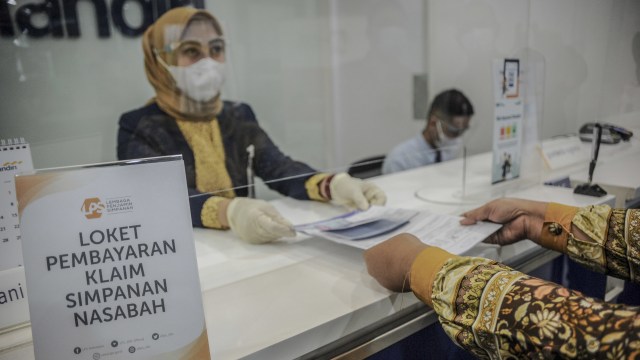 Petugas melayani nasabah yang mencairkan pengembalian dana dari Bank yang telah dilikuidasi di teller Bank Mandiri, Bandung, Jawa Barat, Jumat (29/1/2021).  Foto: Raisan Al Farisi/ANTARA FOTO