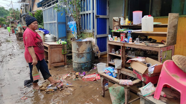 Warga Kota Manado membersihkan rumah mereka dari lumpur akibat banjir yang terjadi