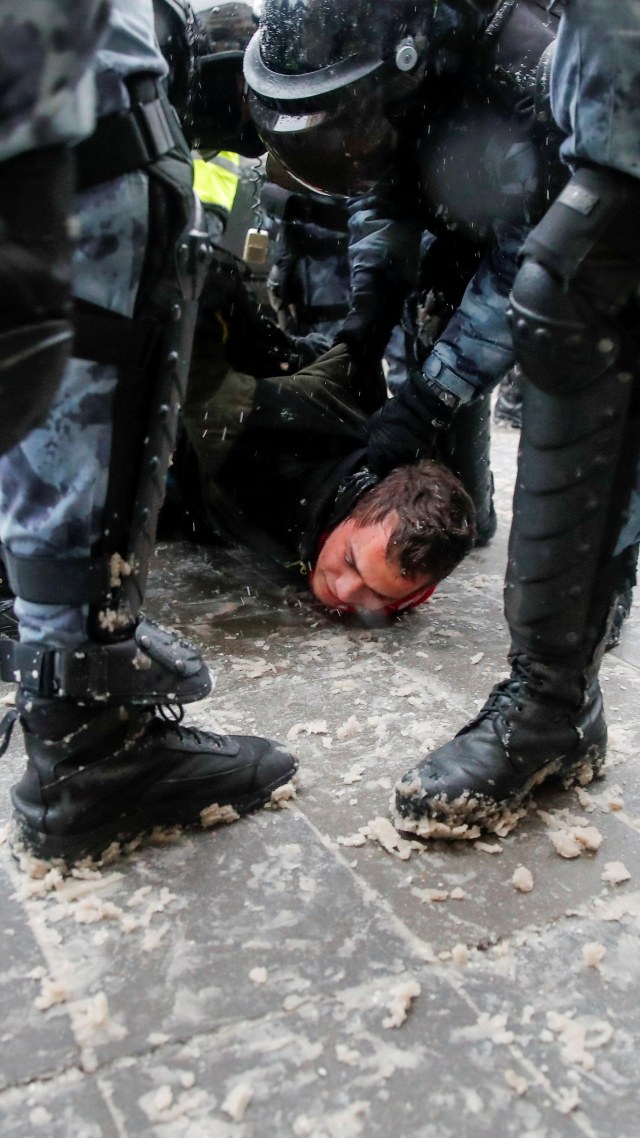 Seorang pria ditahan polisi saat demonstrasi mendukung pemimpin oposisi Rusia Alexei Navalny yang dipenjara di Moskow, Rusia, Minggu (31/1). Foto: Maxim Shemetov/REUTERS