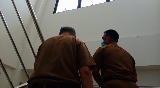 SEKRETARIS Daerah Kota Pekanbaru, Muhammad Jamil (kanan) saat menaiki tangga menuju ruang pemeriksaan di Lantai II Mapolda Riau, Senin (1/2/2021). Ia diperiksa usai dua kali mangkir terkait sengakarut sampah di Pekanbaru.