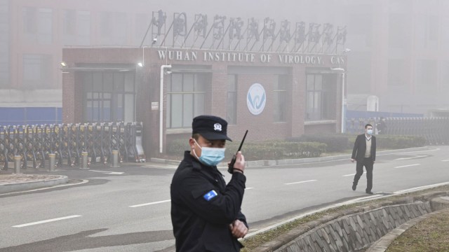 Petugas keamanan berdiri di luar Institut Virologi Wuhan ketika anggota tim Organisasi Kesehatan Dunia (WHO) yang bertugas menyelidiki COVID-19 di Wuhan, China. Foto: Thomas Peter/REUTERS