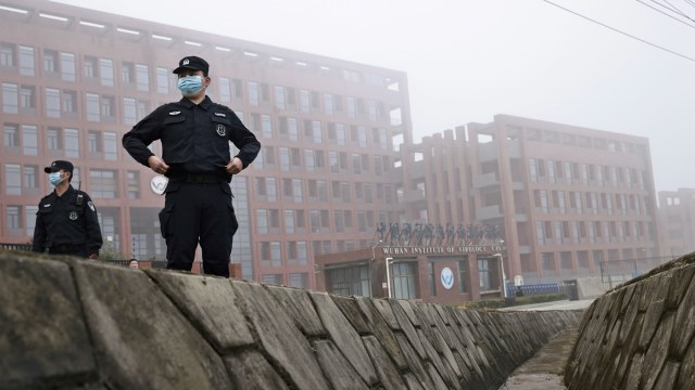 Petugas keamanan berdiri di luar Institut Virologi Wuhan ketika anggota tim Organisasi Kesehatan Dunia (WHO) yang bertugas menyelidiki COVID-a9 di Wuhan, China. Foto: Thomas Peter/REUTERS