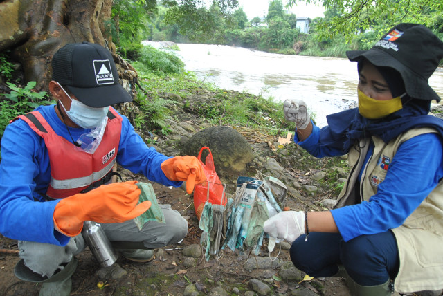 Anggota satgas naturalisasi Ciliwung Kota Bogor mencari sampah masker medis bekas pakai di bantaran sungai Ciliwung, Kelurahan Sukaresmi, Kota Bogor, Jawa Barat, Rabu (3/2/2021). Foto: ANTARA FOTO/Mohammad Ayudha