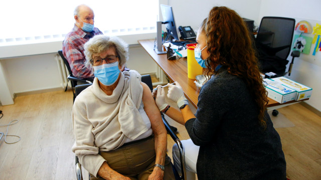 Petugas kesehatan menyuktikkan vaksin corona kepada lansia di Zurich, Swiss. Foto: Arnd Wiegmann/REUTERS