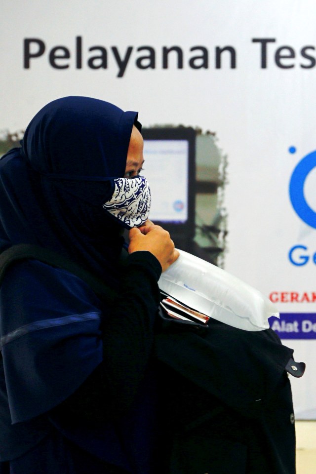 Seorang penumpang meniup kantong plastik untuk mengambil sampel udara yang akan diuji menggunakan GeNose di sebuah stasiun kereta api di Jakarta, Indonesia, Rabu (3/2). Foto: Ajeng Dinar Ulfiana/REUTERS