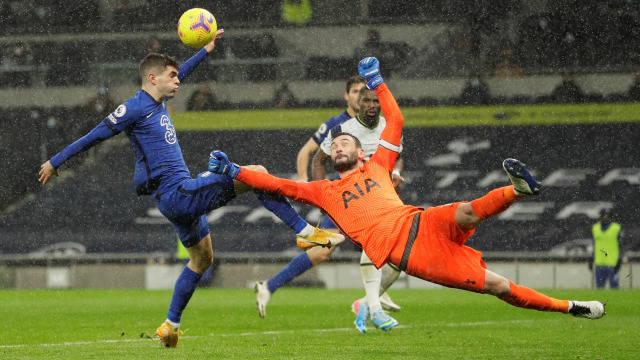 Penjaga gawang Tottenham Hotspsur Hugo Lloris berebut bola dengan pemain Chelsea Christian Pulisic pada pertandingan lanjutan Premier League di Stadion Tottenham Hotspur, London, Inggris.
 Foto: Kirsty Wigglesworth / Pool / REUTERS