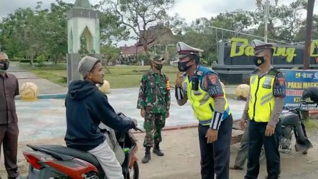 SEORANG pengendara tak memakai masker dan helm terjaring Operasi Yustisi Pemburu Teking COVID-19 di Pasir Pengaraian, Rokan Hulu, Riau. 