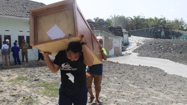 DUA orang santri mengangkat lemari milik Pesantren Al-Ihsan, Jalan Abdurrahman Hamid, Tuah Negeri, Tenayan Raya, Pekanbaru. 