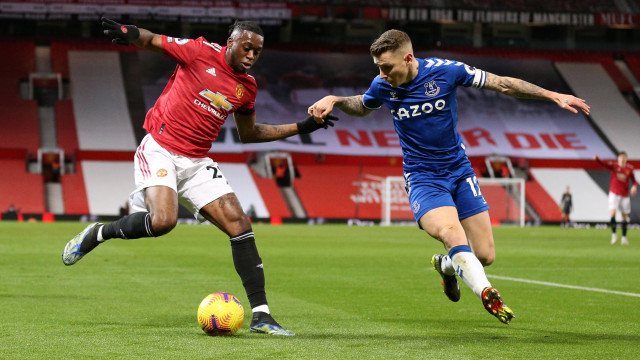 Pemain Mancheter United Aaron Wan-Bissaka berusaha melewati hadangan pemain Everton Lucas Digne pada pertandingan lanjutan Premier League di Old Trafford, Manchester, Inggris Foto: Alex Pantling/Pool/REUTERS