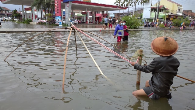 Warga korban banjir di Semarang berburu ikan.  Foto: kumparan