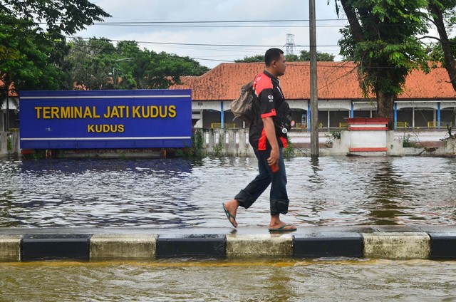 Warga melintasi Terminal Tipe A Jati yang tergenang banjir di Kudus, Jawa Tengah, Minggu (7/2). Foto: Yusuf Nugroho/Antara Foto