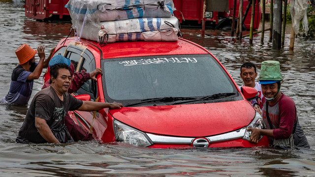 Sejumlah warga mendorong mobil mogok akibat menembus jalur Pantura Jalan Raya Kaligawe - Genuk yang terendam banjir di Genuk, Semarang, Jawa Tengah, Senin (8/2). Foto: Aji Styawan/ANTARA FOTO