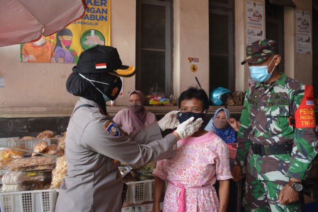 Polisi dan TNI membagikan masker di Pasar Gede Solo