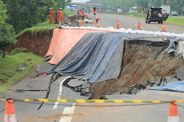 Pekerja memeriksa kondisi jalan tol yang amblas di ruas tol Cikopo-Palimanan (Cipali) KM 122, Kabupaten Subang, Jawa Barat, Rabu (10/2).  Foto: Dedhez Anggara/ANTARA FOTO