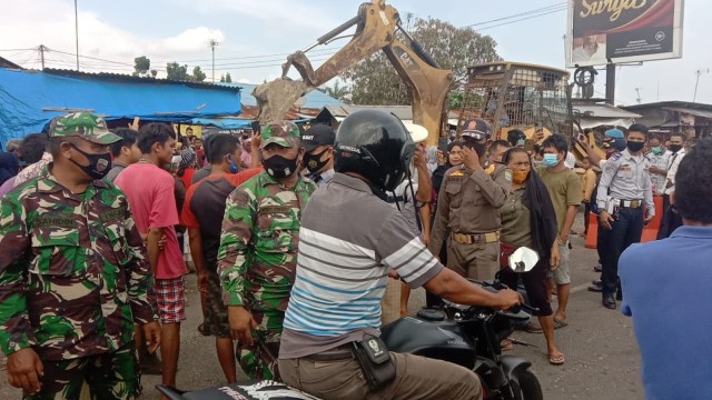 ANGGOTA Satpol PP dibantu polisi dan tentara menertibkan pedagang yang berjualan di Pasar Segitiga, Perawang, Siak, Riau. 