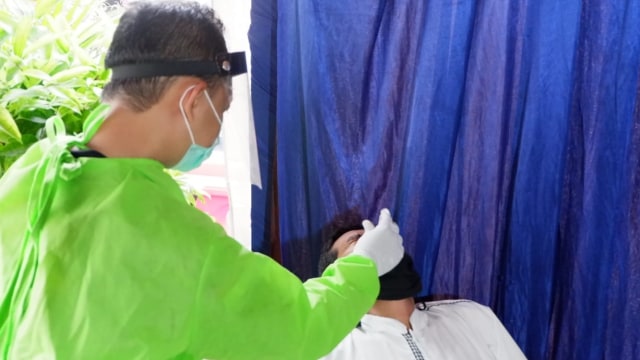 Petugas melakukan rapid test antigen kepada pengendara, di Yogyakarta, Jumat (12/2). Foto: Arfiansyah Panji Purnandaru/kumparan