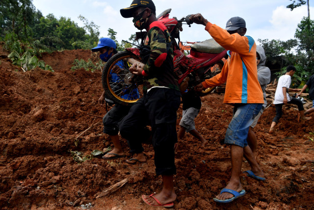 Warga mengevakuasi motor saat pencarian korban tanah longsor di Ngetos, Nganjuk, Jawa Timur, Senin (15/2).  Foto: Zabur Karuru/ANTARA FOTO