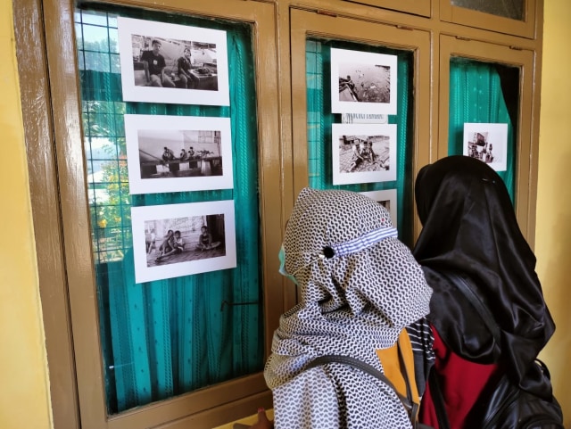 Sejumlah mahasiswa saat melihat hasil karya foto Adlun Fikri. Foto: Julfikar Sangaji