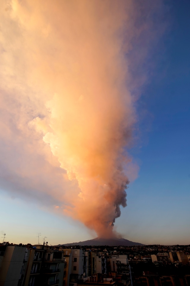 Semburan abu vulkanik terlihat di udara saat Gunung Etna erupsi, terlihat dari desa Catania, Italia, Selasa (16/2/2021). Foto: Antonio Parrinello/REUTERS