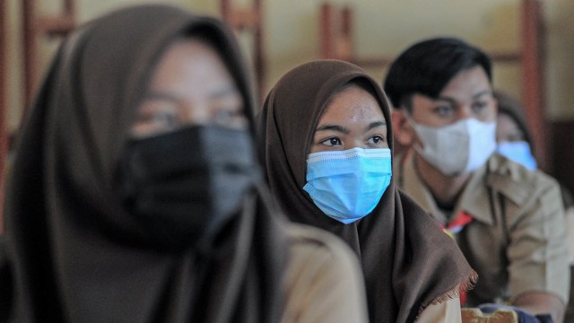 Siswa mendengarkan materi pelajaran sambil mengenakan masker saat hari pertama dimulainya kembali belajar tatap muka di SMAN 5 Kota Jambi, Jambi, Rabu (17/2/2021). Foto: Wahdi Septiawan/ANTARA FOTO