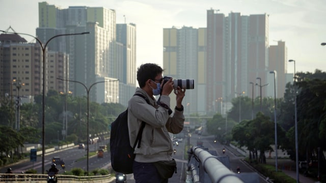 Seorang fotografer saat memotret. Foto: Jamal Ramadhan/kumparan