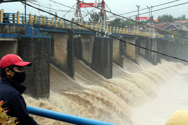 Warga melihat debit air yang deras, di Bendung Katulampa, Kota Bogor, Jawa Barat, Jumat (19/2). Foto: Arif Firmansyah/Antara Foto