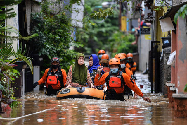 Relawan dari Dompet Dhuafa mengevakuasi warga yang terjebak banjir di Cipinang Melayu, Jakarta Timur, Jumat (19/2).  Foto: Sigid Kurniawan/ANTARA FOTO
