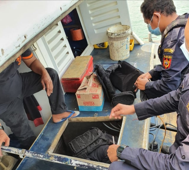 Petugas Bea Cukai memeriksa lantai SB Rahmat Jaya yang diduga menjadi tempat menyimpan barang-barang selundupan. Foto: Istimewa